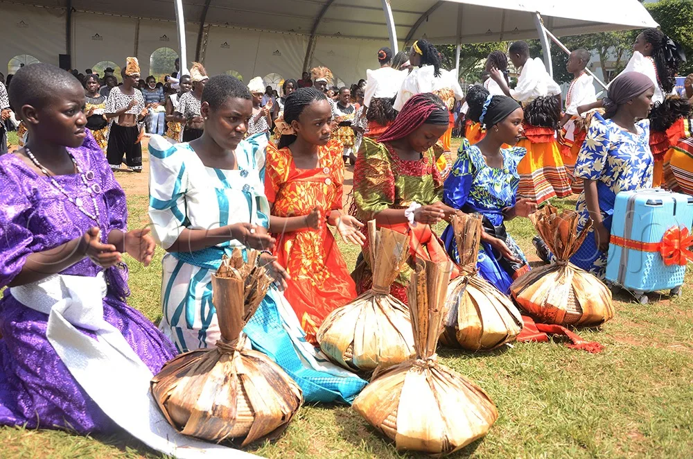 ekisakaate-young-girls-kneel-with-traditionally-wrapped-gifts