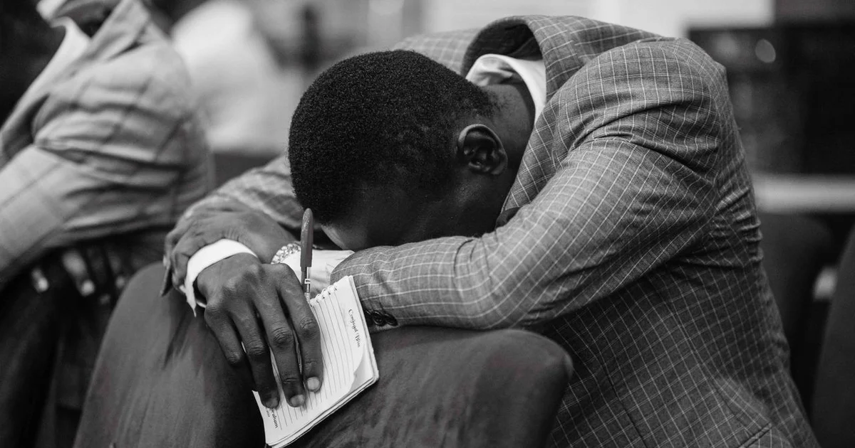 man-in-prayer-with-notepad-in-hand