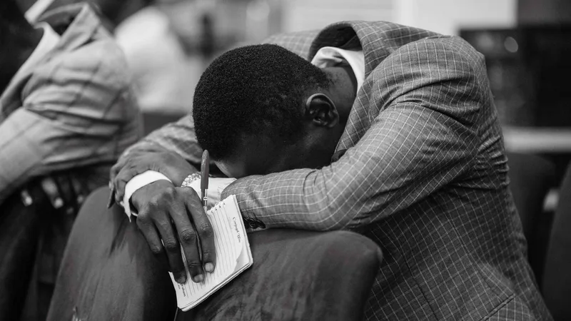 man-in-prayer-with-notepad-in-hand