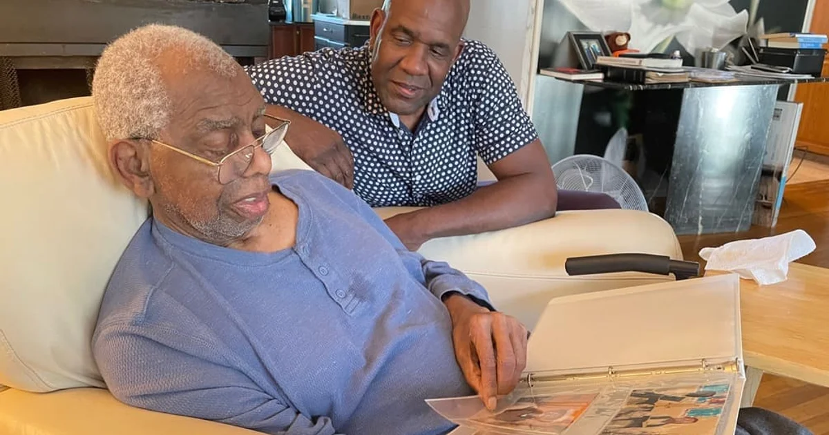 elderly-african-man-with-son-looking-at-photo-album